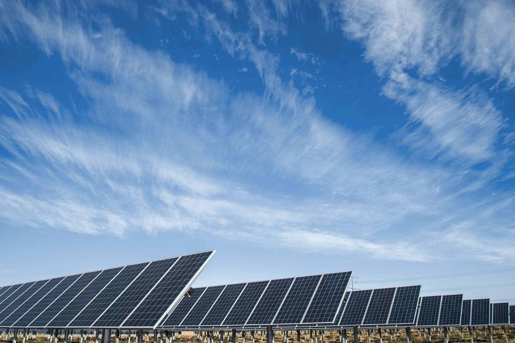 A row of ground-mounted solar panels under open sky